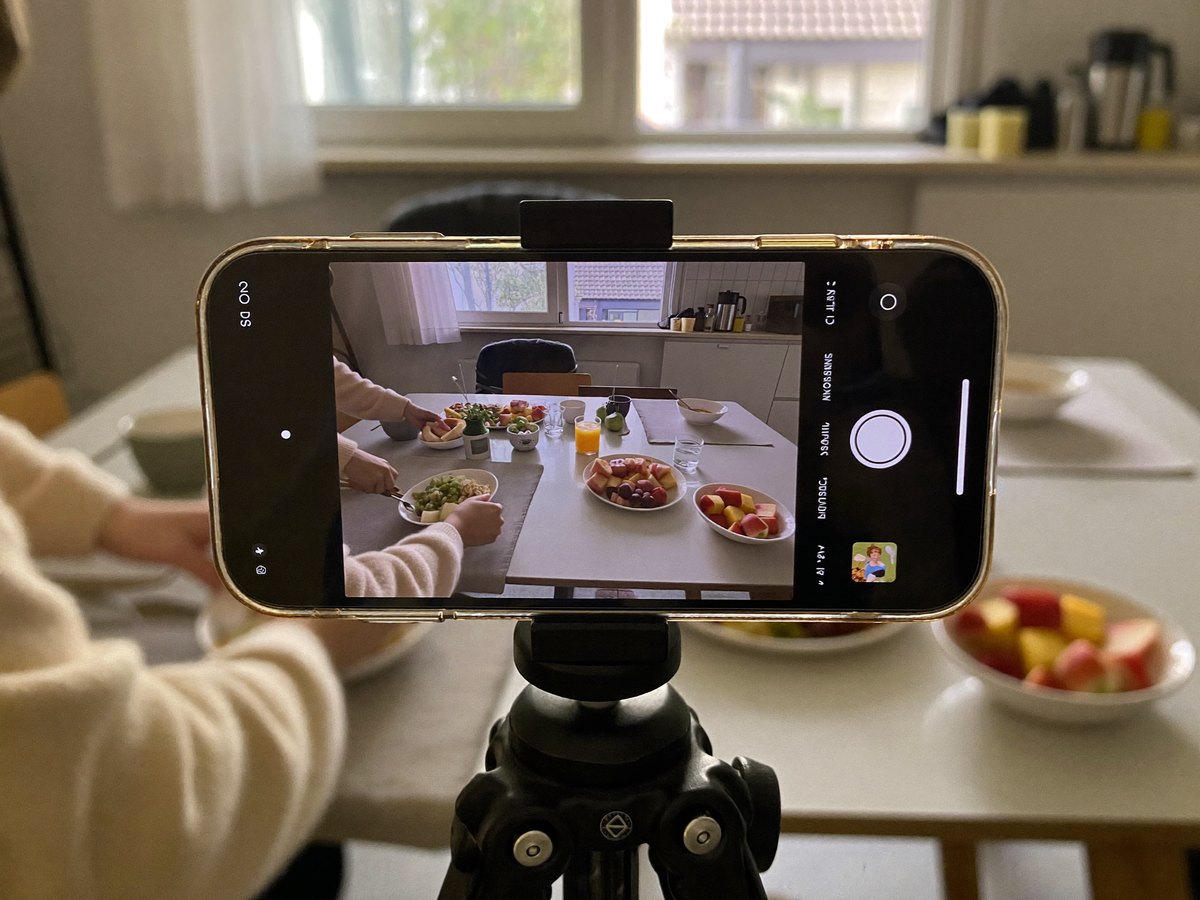 Phone on a tripod filming a family breakfast